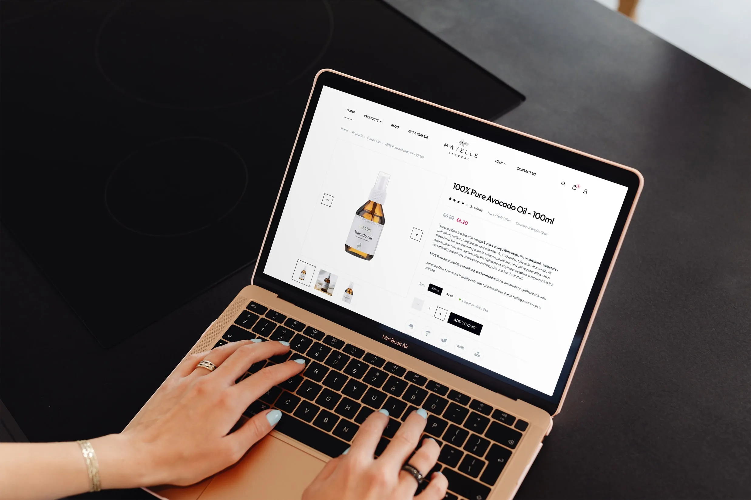 Hands typing on a laptop that shows the avocado oil product page